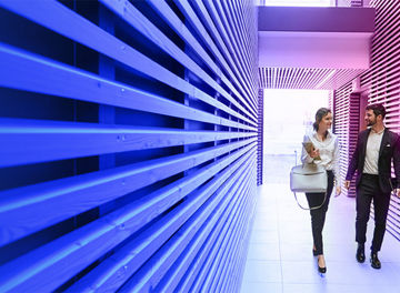 Two people walking in corridor