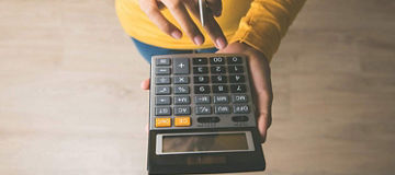 Person using calculator, seen from above