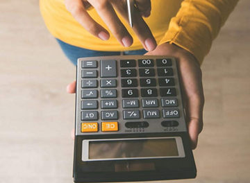 Person using calculator, seen from above
