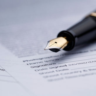 Fountain pen lying on scattered legal contract documents on table, shot with very shallow depth of field