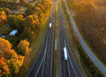 USA highway transportation infrastructure at sunset. American freeway road with fast driving cars