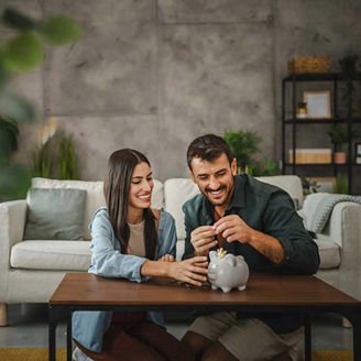 Couple save money coins in the piggy bank at home representing Ireland's new investment account