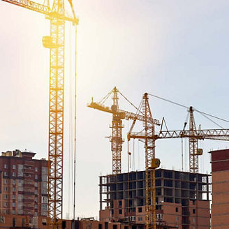 Number of cranes at a building site with lens flare