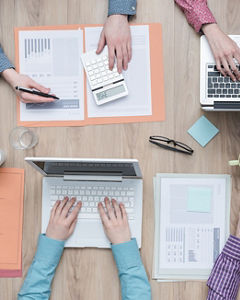 Business meeting seen from above with laptops and hands on the table