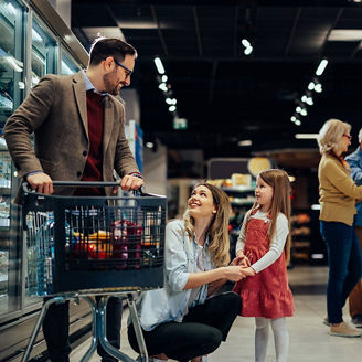 Cheerful family with one girl shopping groceries in supermarket