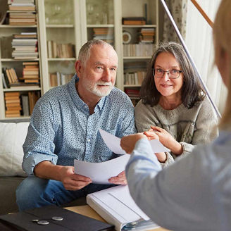 Couple of seniors getting advice on retirement and care from a senior counselor or social worker