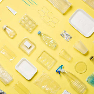 Different types of used plastic packaging arranged on a yellow background