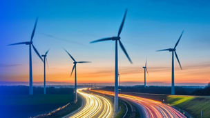 Wine turbines amid neon light trails on busy road