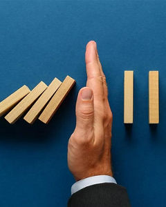Hand stopping dominoes from falling
