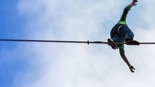 Man balancing on tightrope