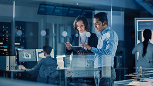Two people looking at tablet in office