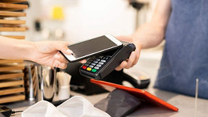 Woman paying in cafe with smartphone - contactless payment