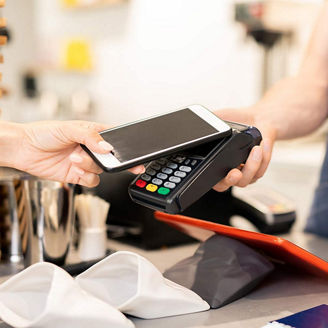 Woman paying in cafe with smartphone - contactless payment