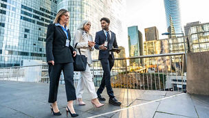 3 people walking in financial district representing financial services