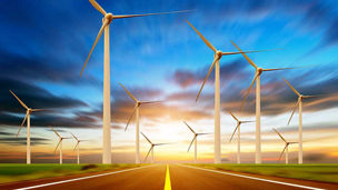 Wind power stations and highway at sunset time representing Utilities Regulatory and Transformation