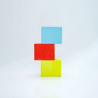 three rectangular foam blocks, Blue, yellow and red, stacked with offset on white background
