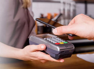 Person using contactless payment in cafe