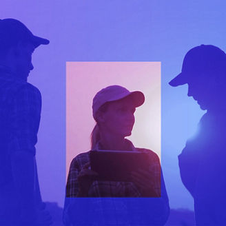 Female farmer speaking to two male farmers in a field