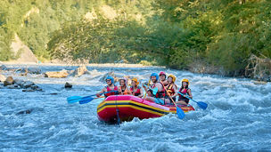 A group of people rowing a small boat 