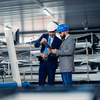 Fotografía de dos hombres ejecutivos visitando una planta de manufactura