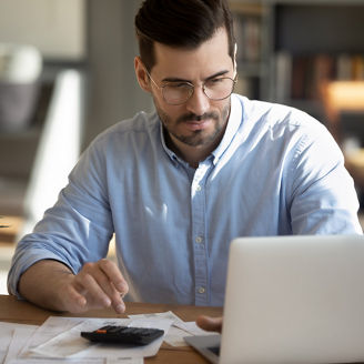 Focused young Caucasian man look at laptop screen calculate expenses expenditures pay bills taxes online. Millennial male busy managing household family budget, take care of financial paperwork.
