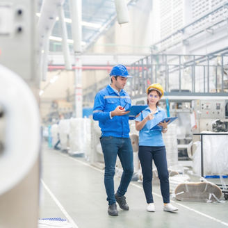 Fotografía de un hombre y una mujer trabajando en una planta de manufactura