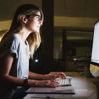 Fotografía de una mujer trabajando durante la noche en la oficina