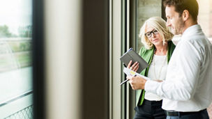 Portrait of smiling blond businesswoman communicating with a colleague