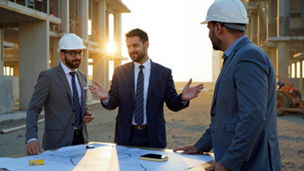 Collaborative Team of Indian Engineers Reviewing Blueprints at Urban Job Site