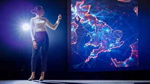 A person looking at a digital map in a dark room with a spotlight