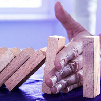  Frauenhand stoppt Dominosteine