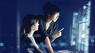 Two people looking at a screen in a dark room