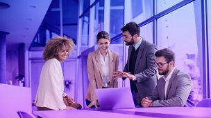 People discussing whilst looking at a laptop