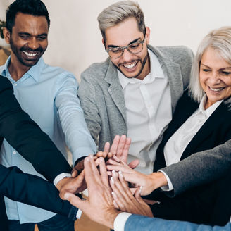 Multiracial business people celebrating together stacking hands inside modern office - Focus on asian man face