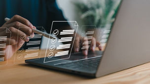 Two people using a tablet and calculator with documents in front of them on a table