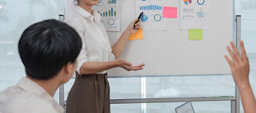 Presentation in Office Conference Room. Meeting of Diverse Young Entrepreneurs, Specialists, Talking, Using whiteboard business analysis and presentation for meeting.