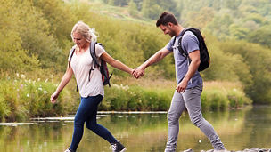 man and woman stepping on stones