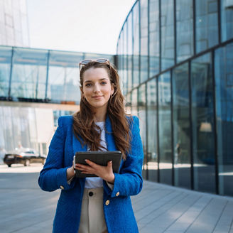 Successful woman real estate agent holding tablet and looking to camera. Business centre location. High quality photo