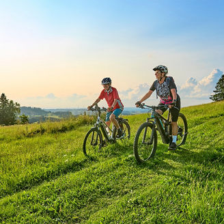 two-cyclists-downhill-grass