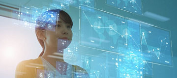 Person standing with arms crossed in front of multiple translucent digital screens displaying charts, graphs, and interface elements