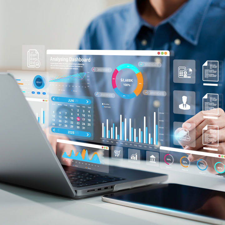 A person using a laptop with floating graphs hologram 