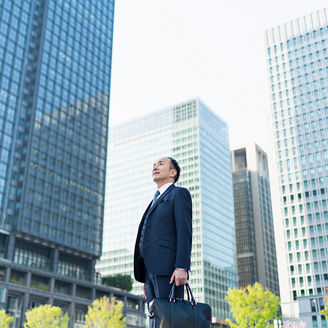 ビルの間で空を見上げる人