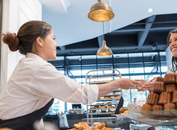 おしゃれなベーカリーで買い物をする女性