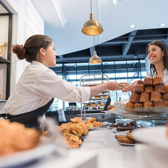 おしゃれなベーカリーで買い物をする女性