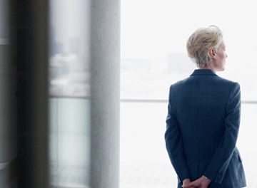 窓から外を眺める女性の後ろ姿