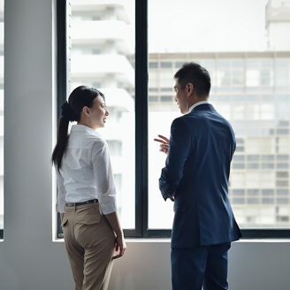 窓際で向き合って話し合う男女