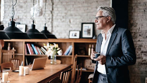 Japanese alt text: ティーカップを持ち微笑む男性