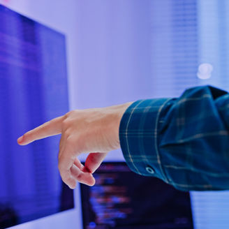 モニターを指さす腕