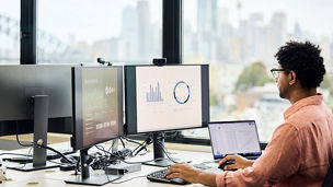 Businessman analyzing sales graph on computer screen at office. Entrepreneur is preparing finance data. He is using keyboard and mouse.
