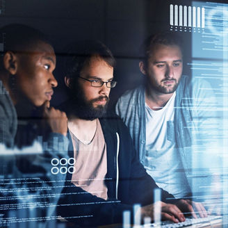 Three people are working in front of a monitor